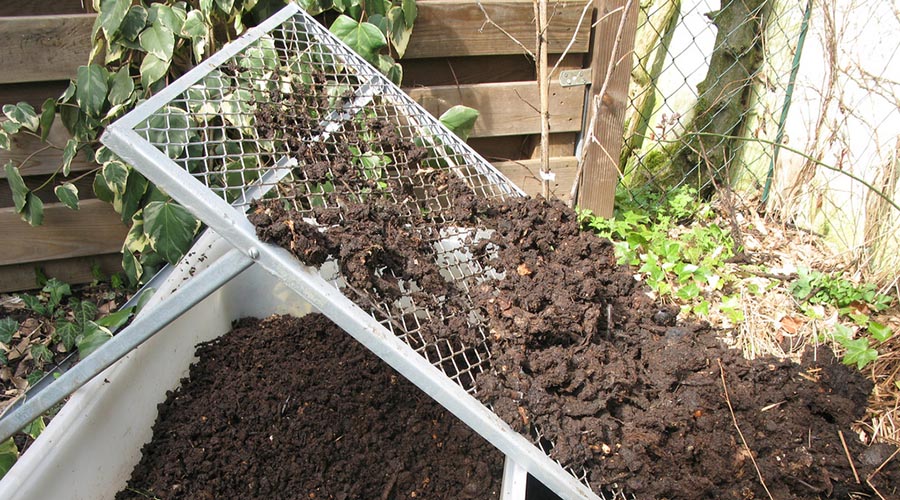 Compostador comunitario en huerto.