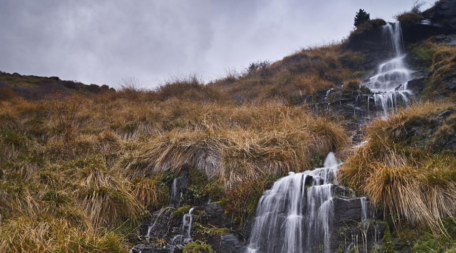 Pequeña cascada de agua natural de montaña árida.