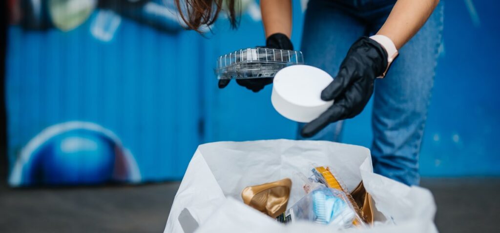 Mujer clasificando residuos mezclados de bolsa de basura.