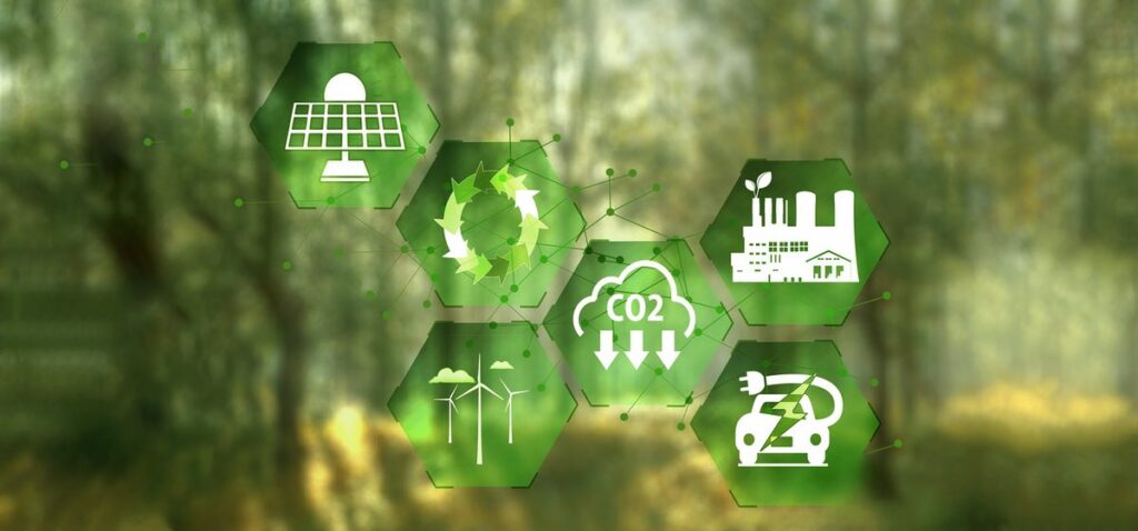 Iconos emisiones CO2, energías renovables y economía circular sobre fondo de bosque difuminado.